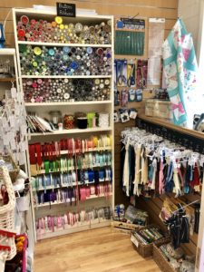 Haberdashery section of shop with buttons and zips